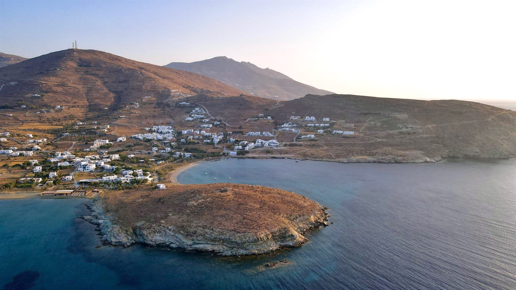 Agios Ioannis bay at sunset, the headland and village in golden light