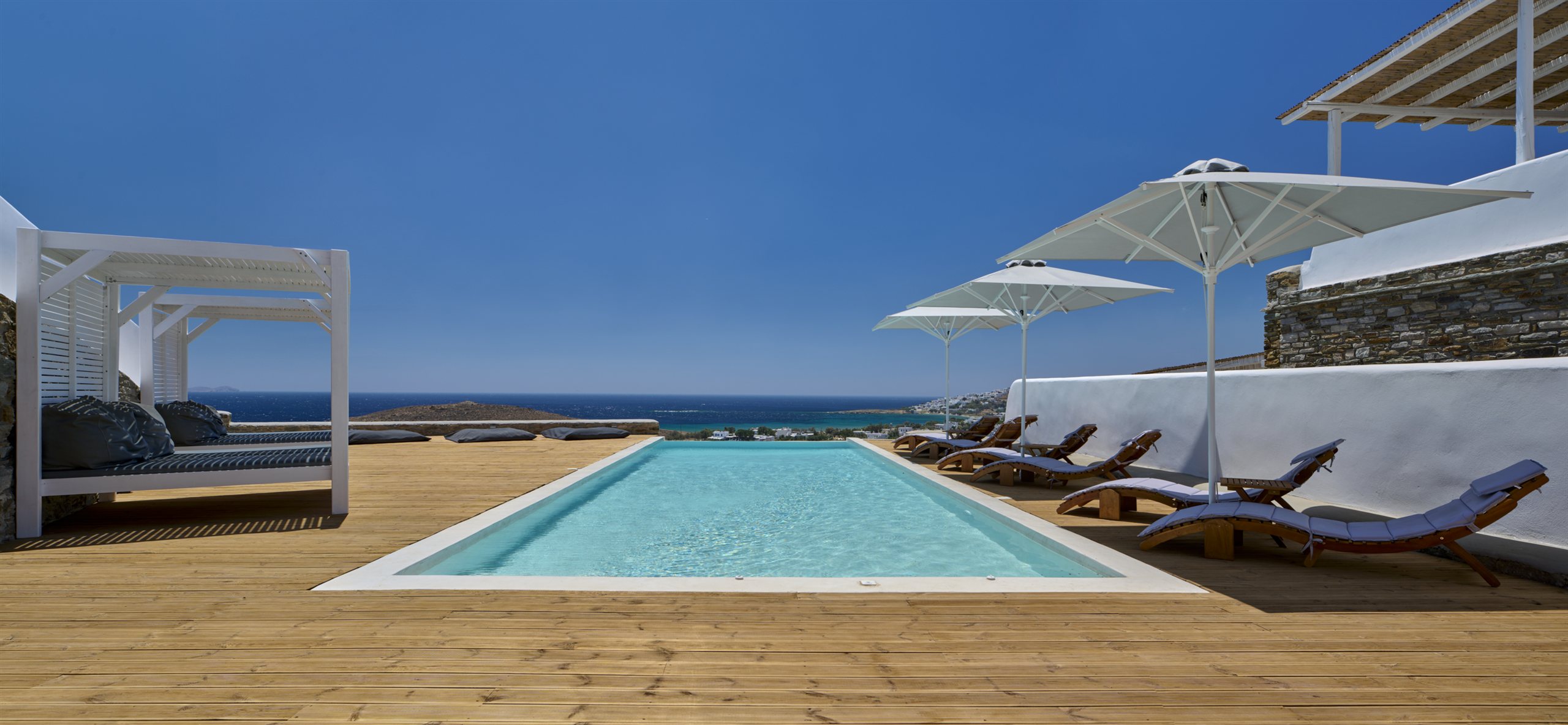 The shared pool on its wooden deck, looking out over the bay toward Delos and Mykonos